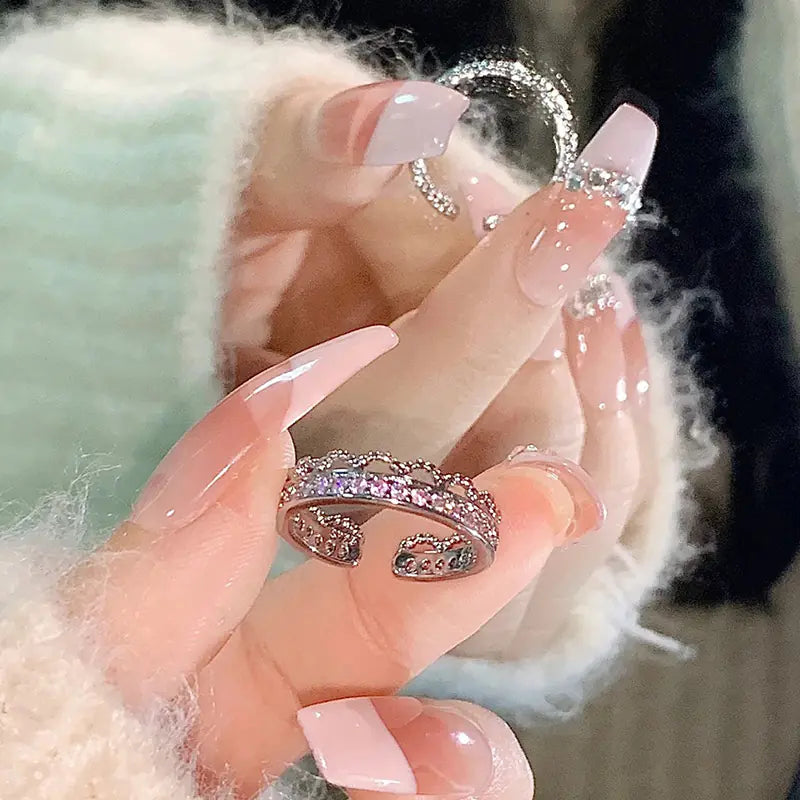 Hand holding two sparkling rings with a soft blurred background