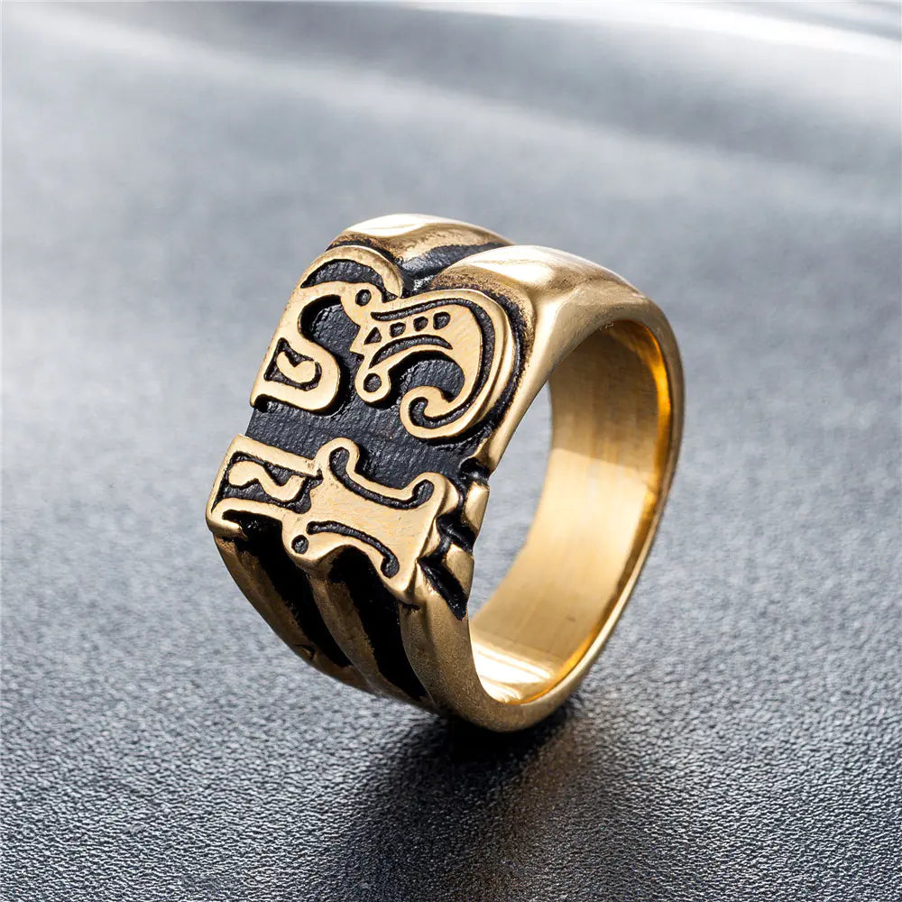 Gold and black skull ring on a gray background