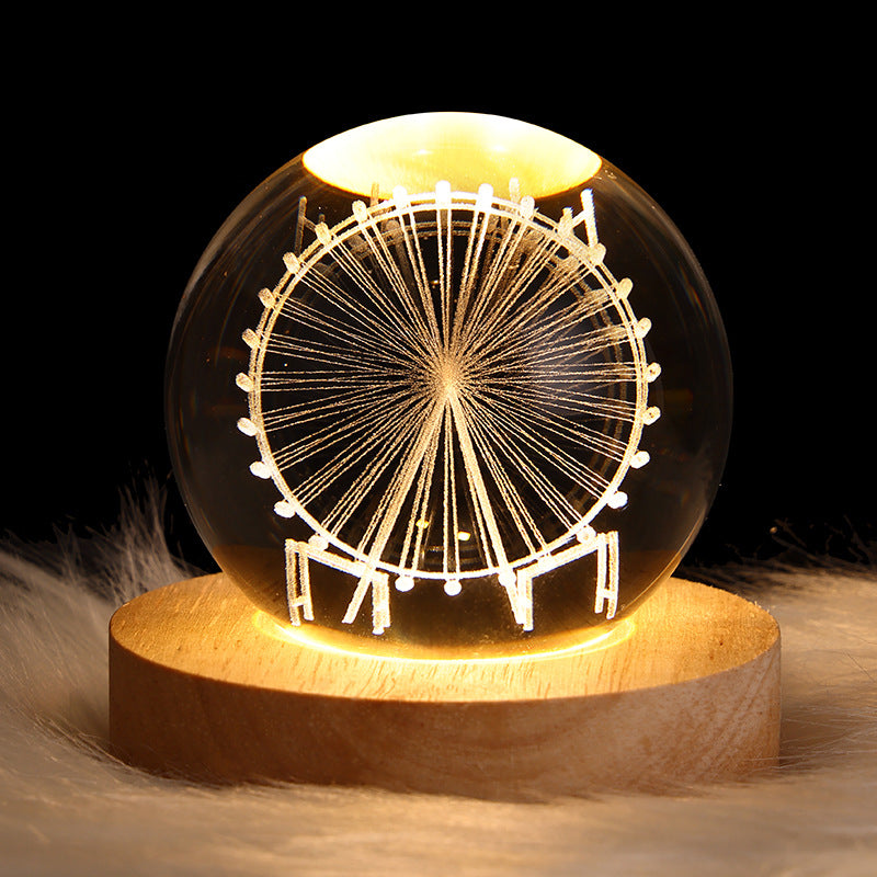 Glass sphere with a Ferris wheel design on a wooden base against a dark background