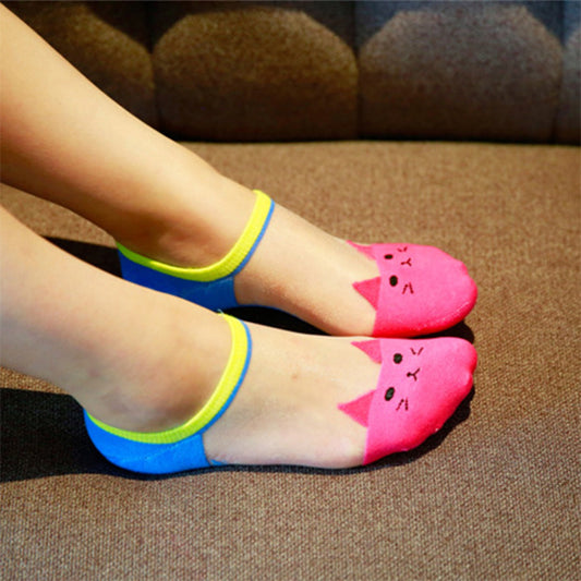 Colorful cat-shaped socks worn on a brown surface