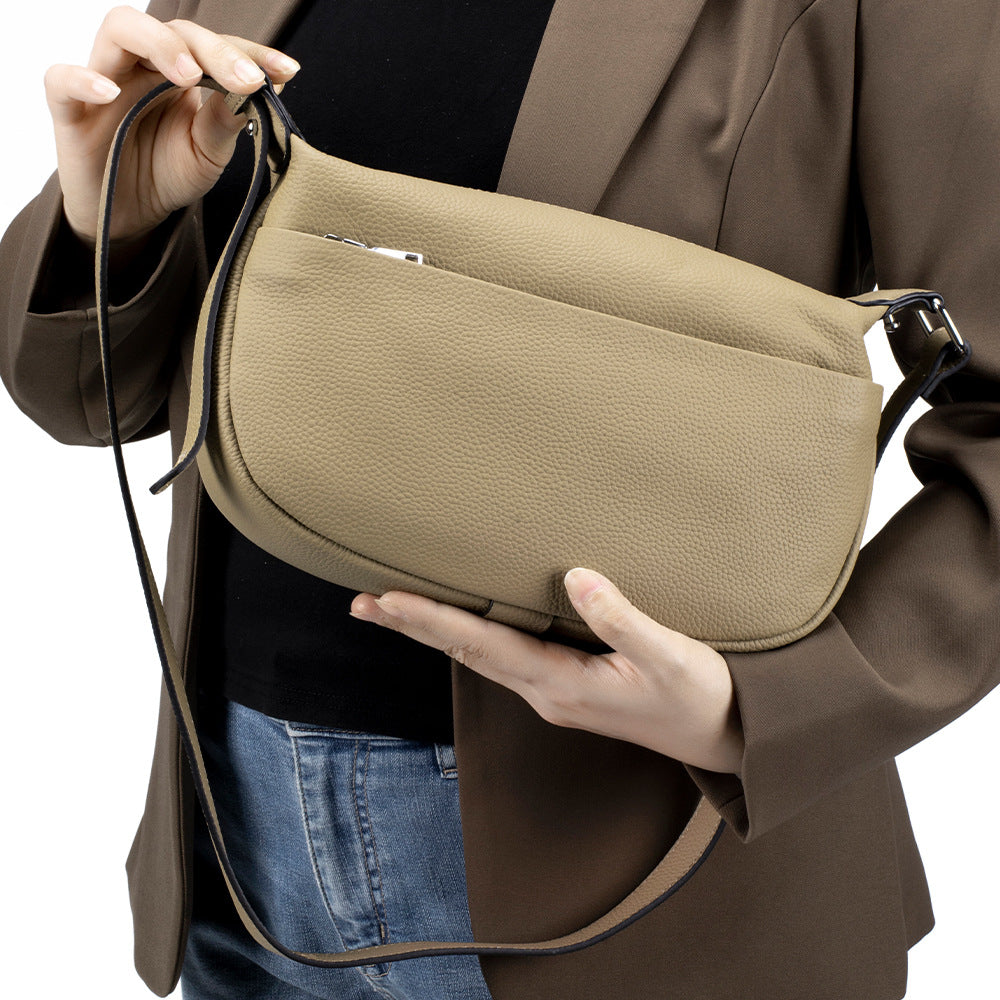 Person holding a beige handbag against a neutral background