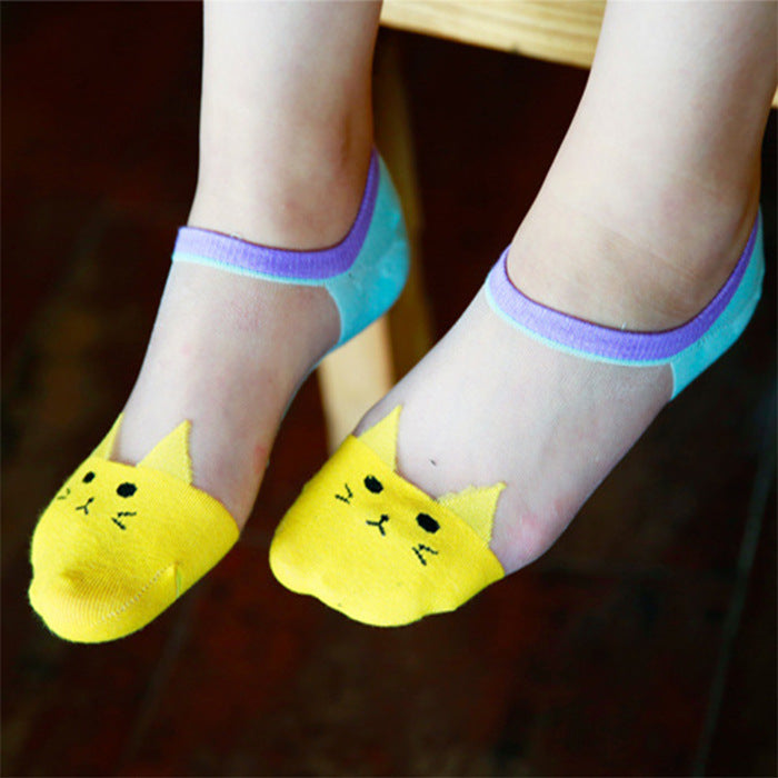Children's feet wearing yellow cat-shaped socks with transparent tops.