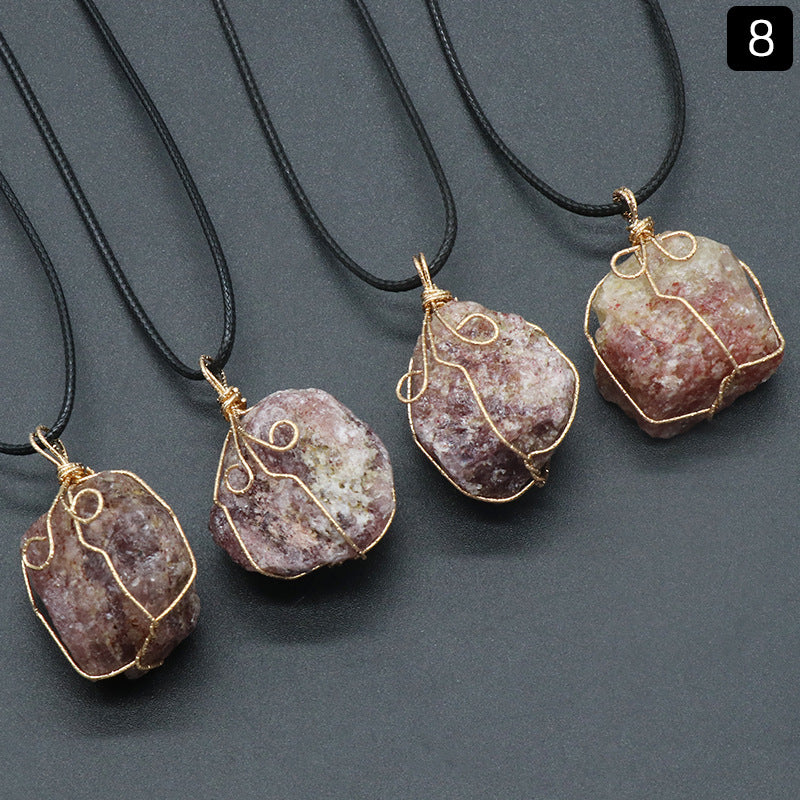 Four stone pendants on black cords against a gray background