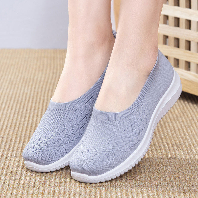 Light blue slip-on shoes worn by a person on a textured surface