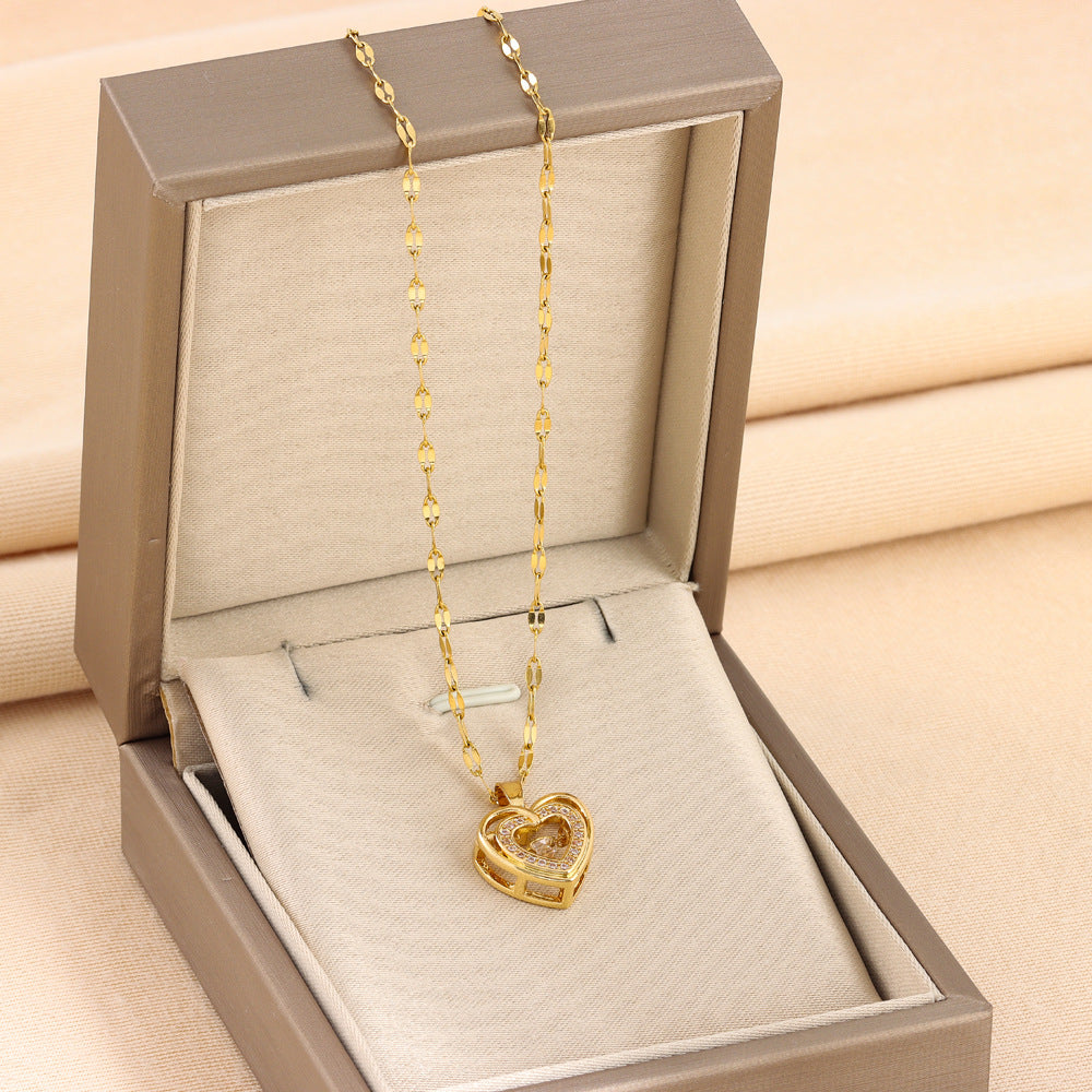 Gold heart-shaped necklace in an open jewelry box on a beige background