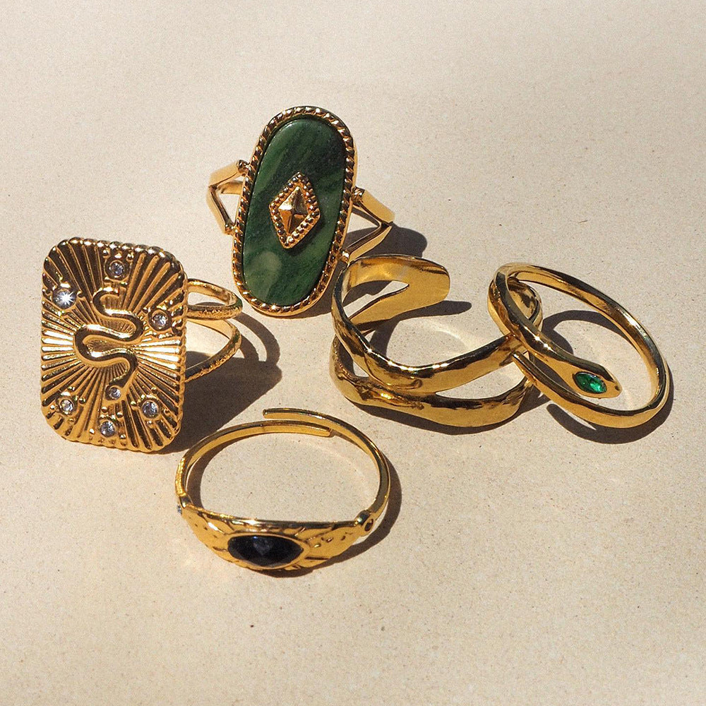 Set of gold rings with gemstones on a beige background