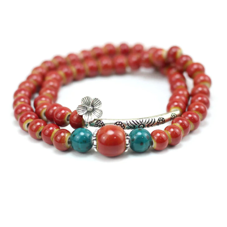 Beaded bracelet with red and turquoise beads on a white background