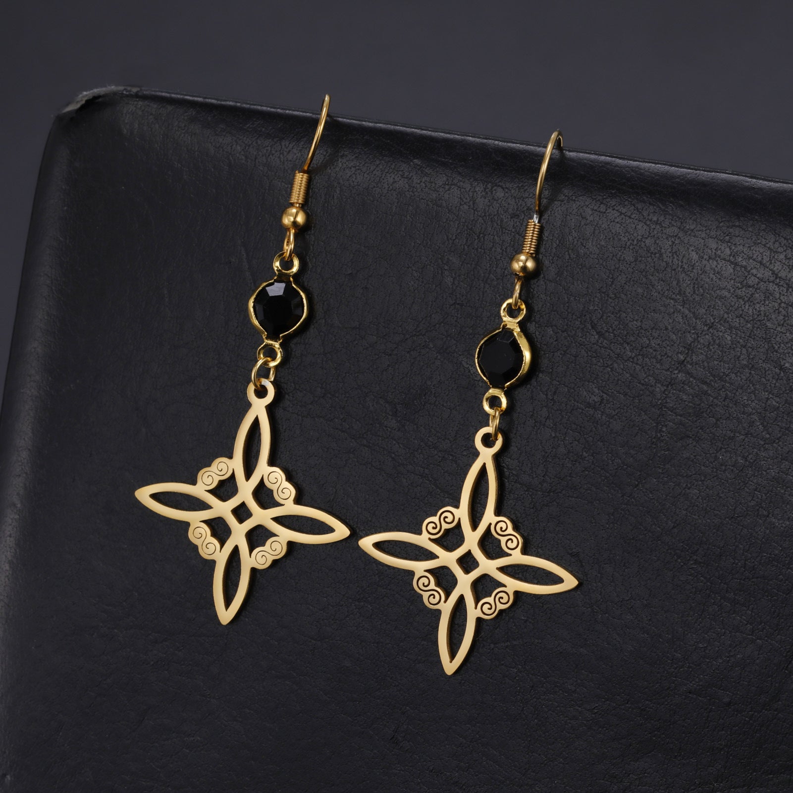 Gold butterfly-shaped earrings on a black background