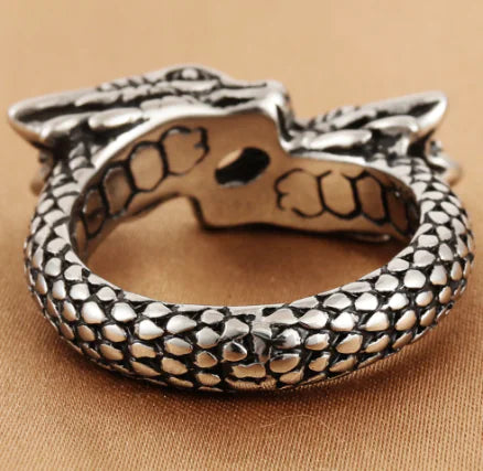 Silver bracelet with snake design on a beige background
