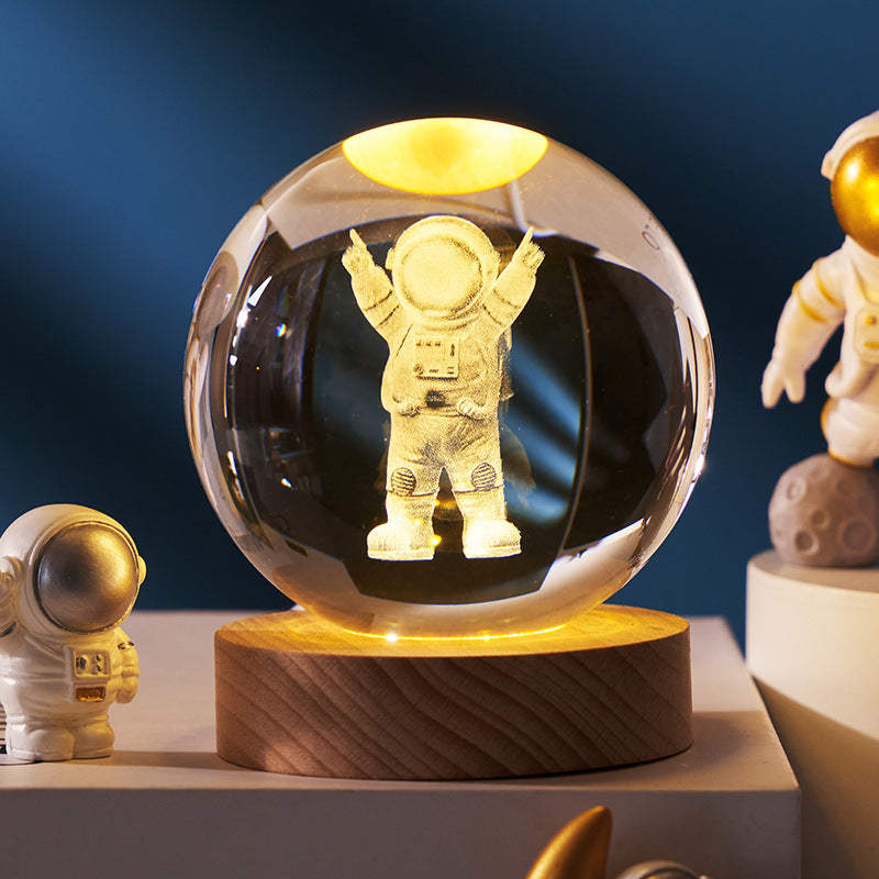 Crystal ball with an astronaut figure inside, surrounded by space-themed decor on a blue background