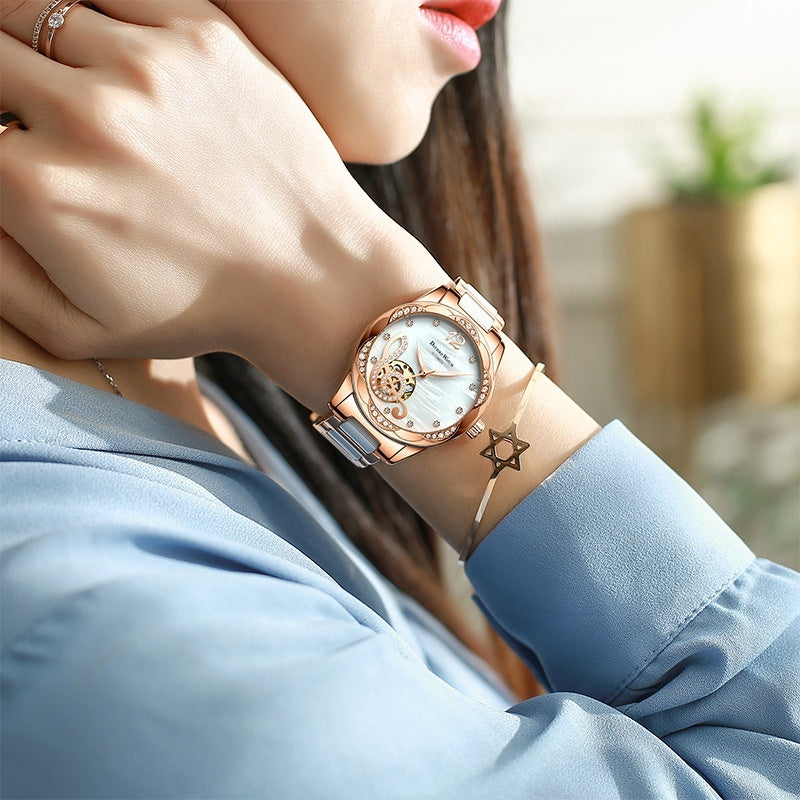 Close-up of a person wearing a rose gold watch with a blurred background