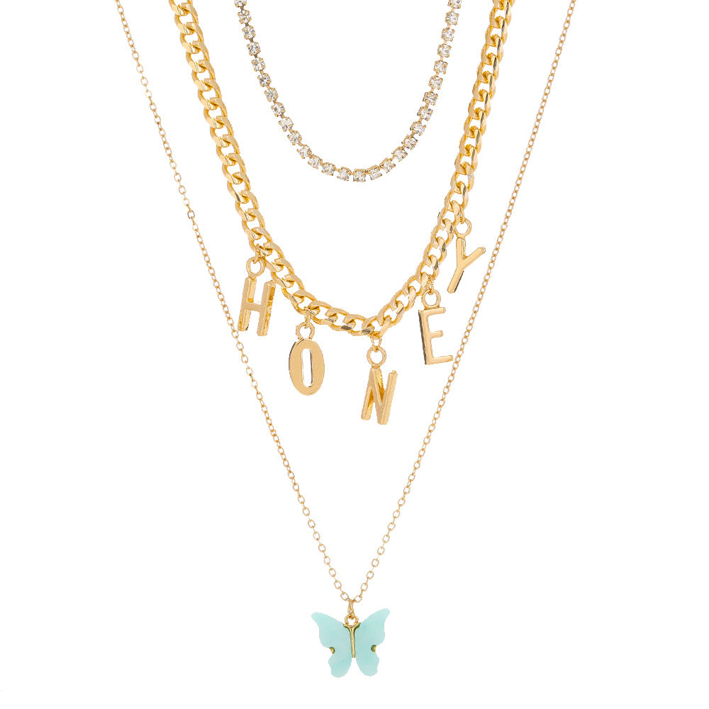 Three gold necklaces with 'HONEY' and a butterfly pendant on a white background
