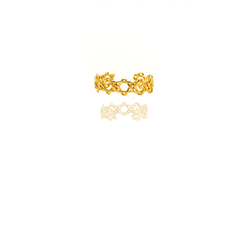 Gold ring with intricate design on a white background