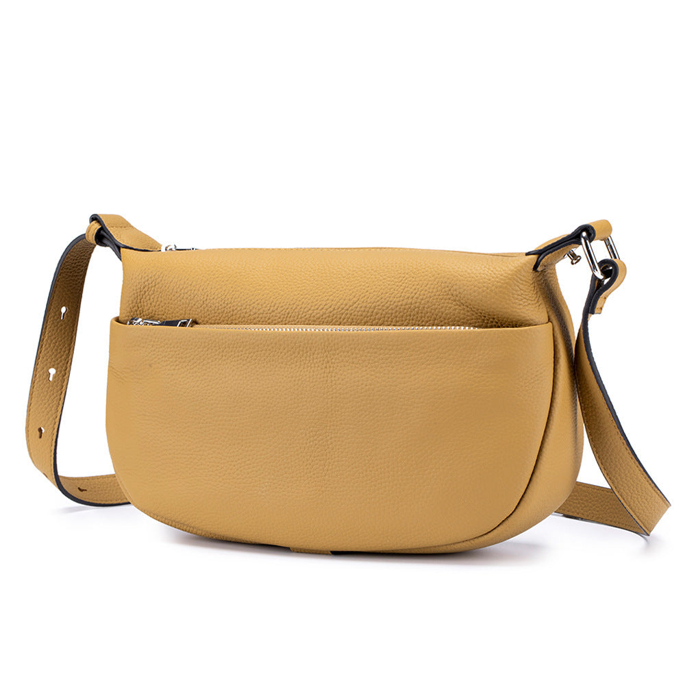 Yellow leather handbag with a strap on a white background