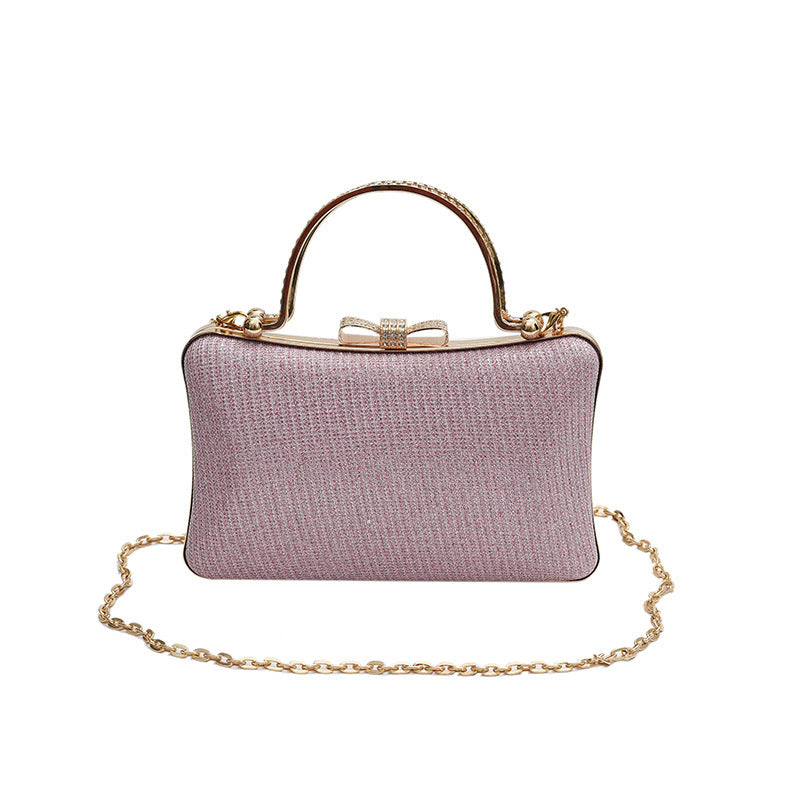 Pink handbag with gold chain and handle on a white background