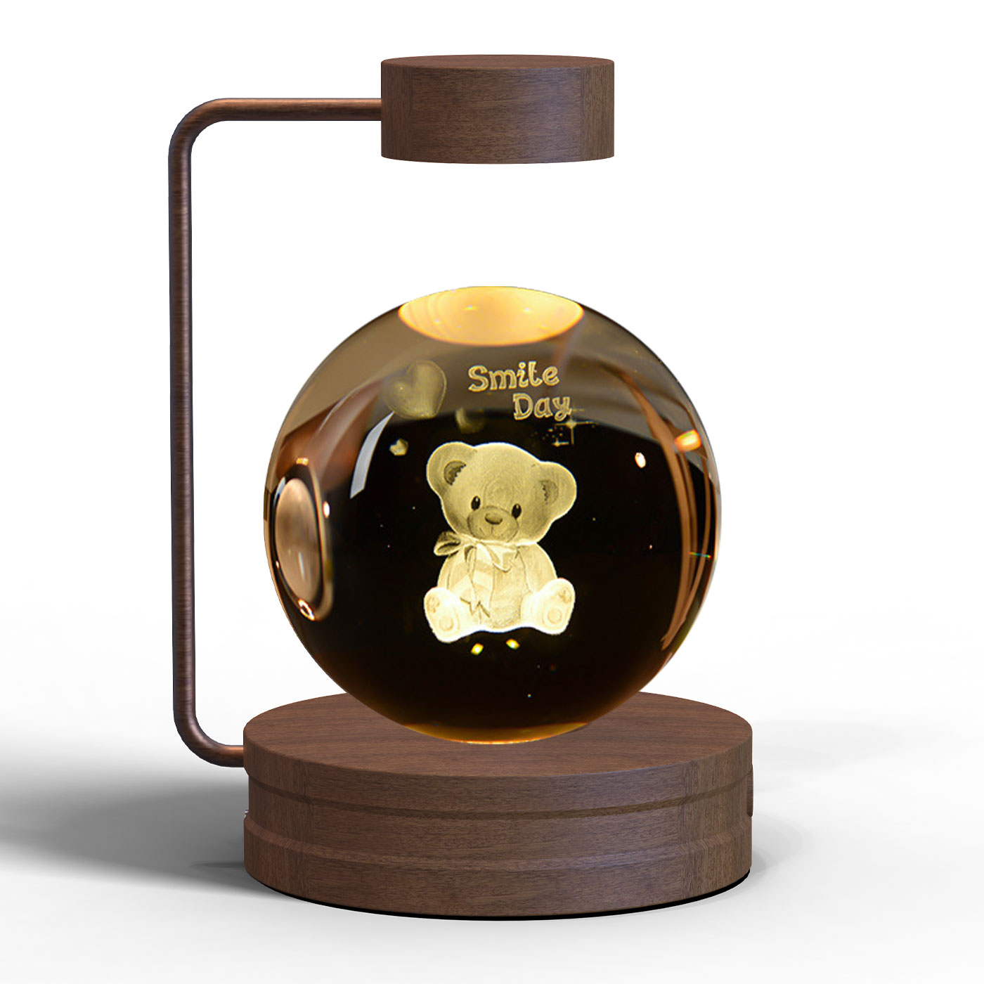 Levitating glass ball with a teddy bear inside, featuring the text 'Smile Day', on a wooden stand.