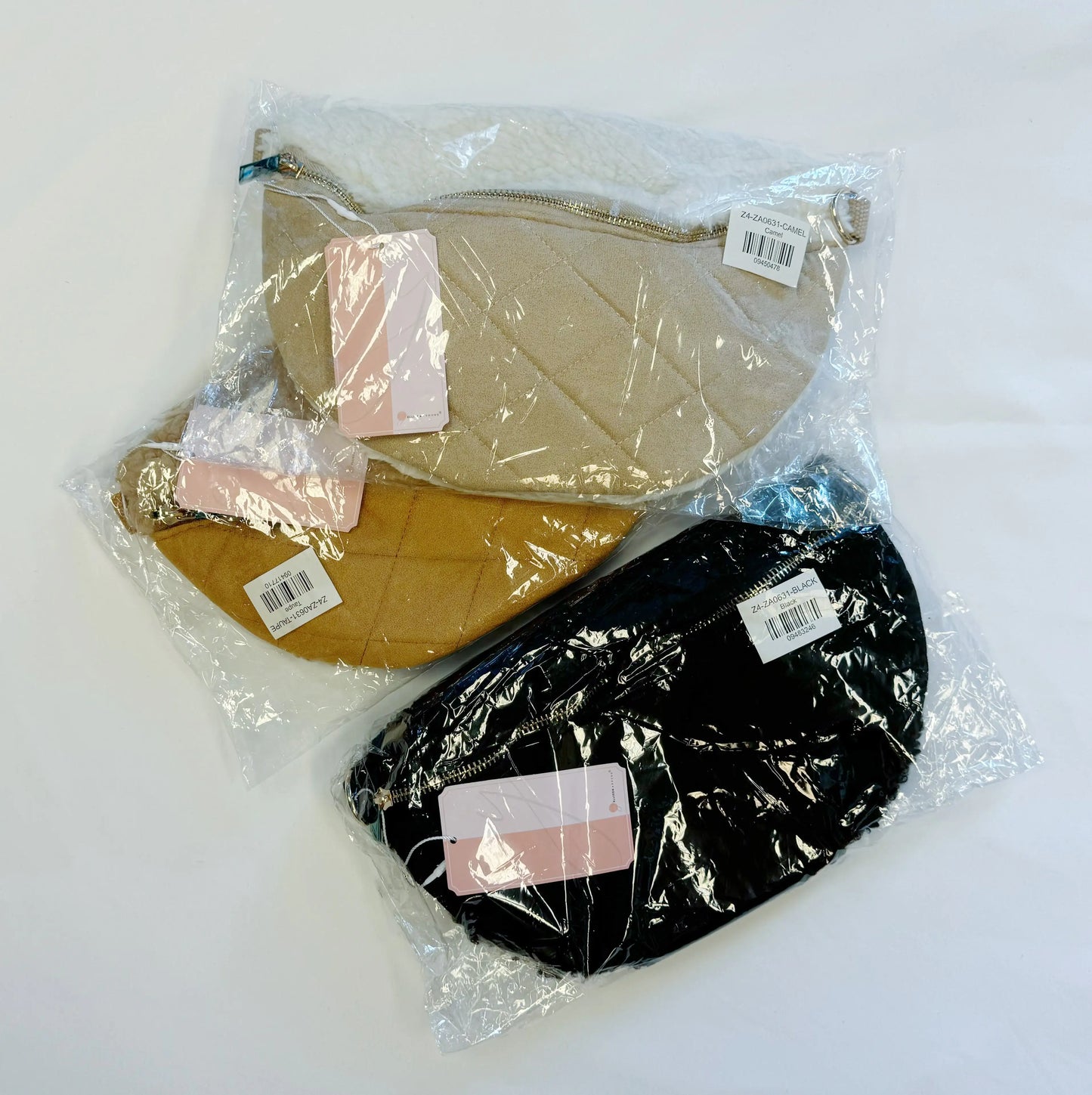 Two quilted bags, one beige and one black, in clear plastic packaging on a white background.