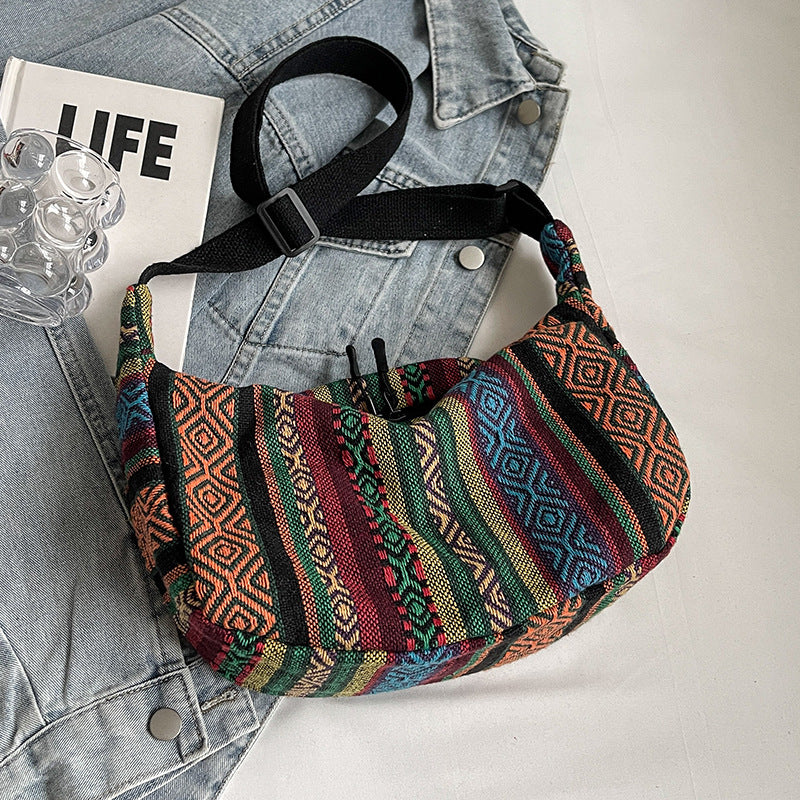 Colorful patterned bag on a denim jacket with a magazine underneath