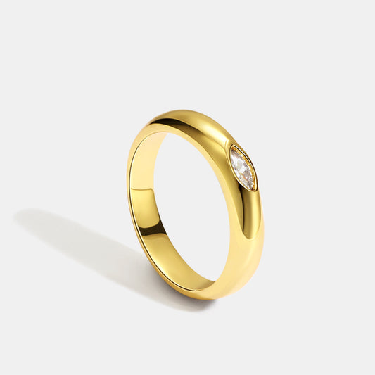 Gold ring with a diamond on a light gray background