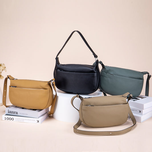 Four handbags in different colors on a light beige background