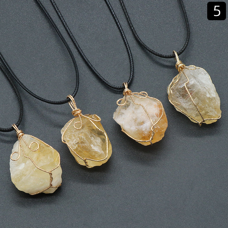 Five stone pendants on black cords against a gray background