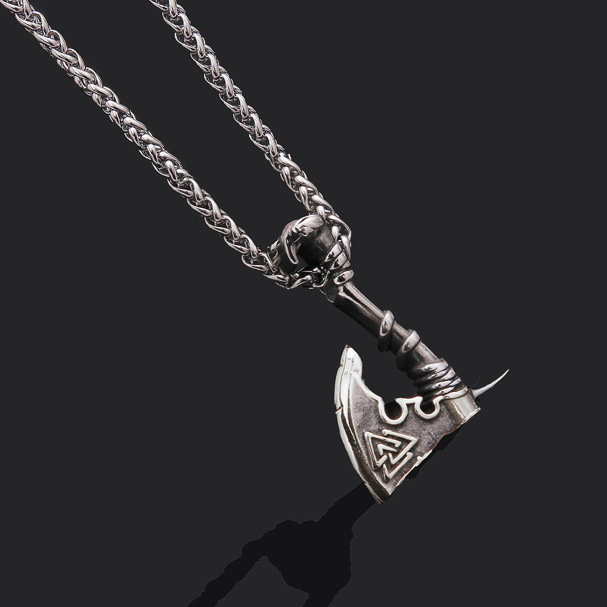 Silver axe pendant necklace on a dark background