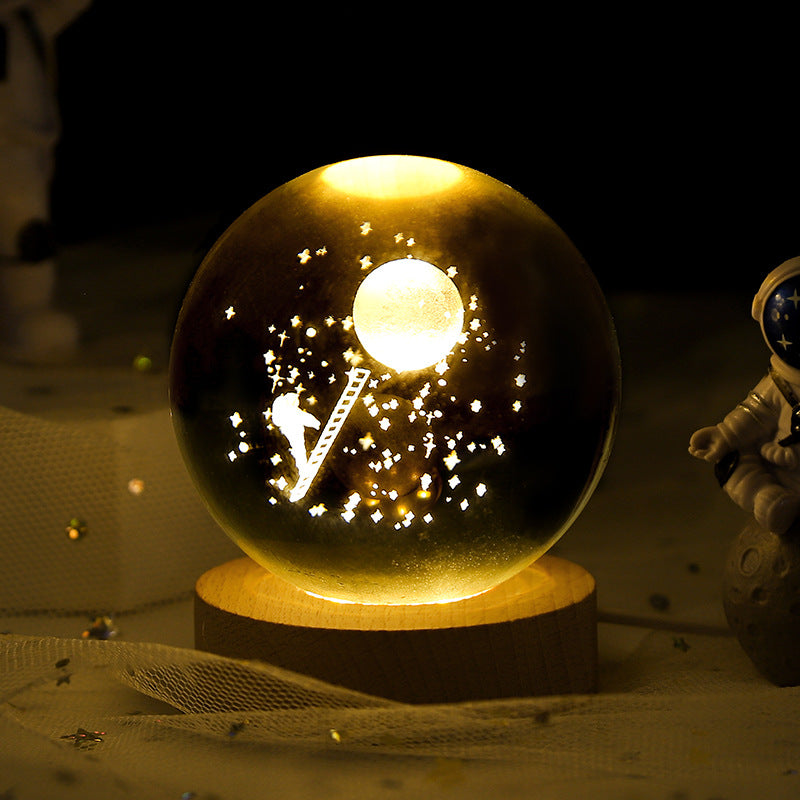 Decorative lamp with astronaut and moon design inside a glass sphere on a wooden base.