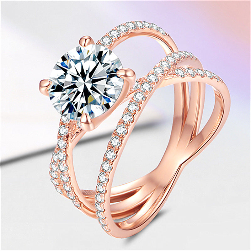 Rose gold ring with a large diamond and smaller diamonds on a light background