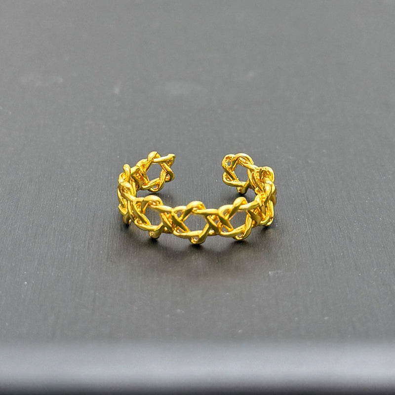 Gold ring with intricate design on a gray background