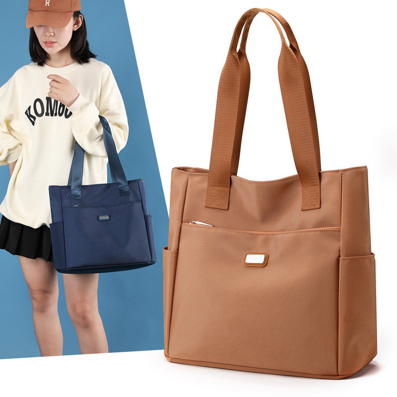 Brown tote bag with a person holding a blue bag on a white background