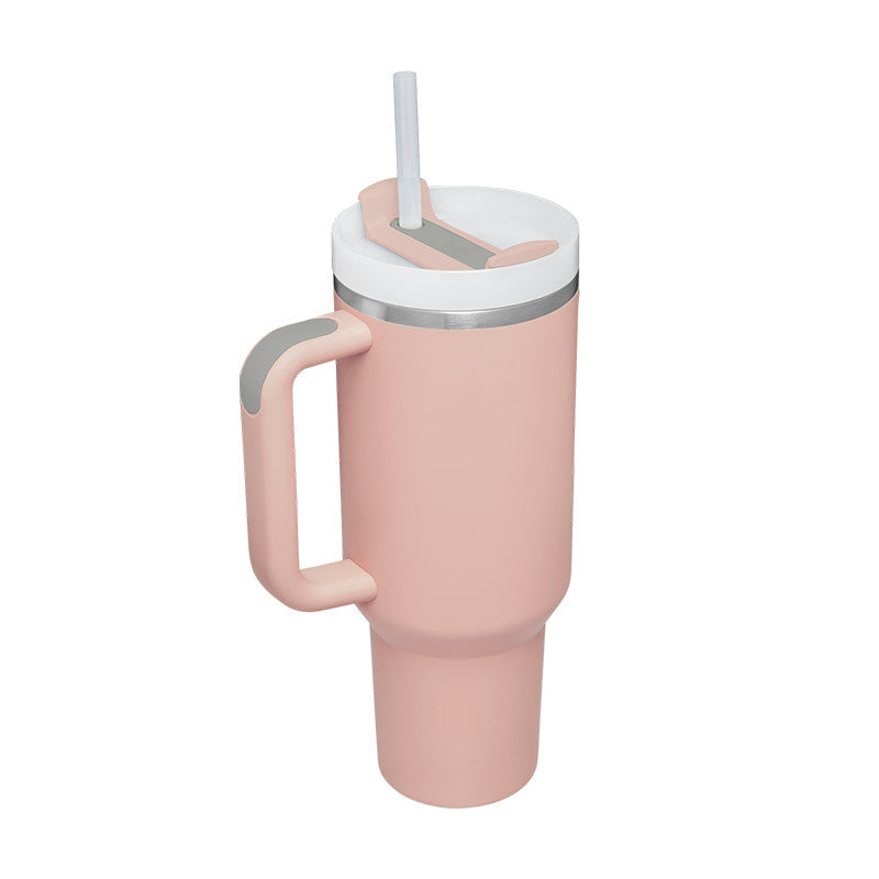 Pink tumbler with a handle and white lid on a white background