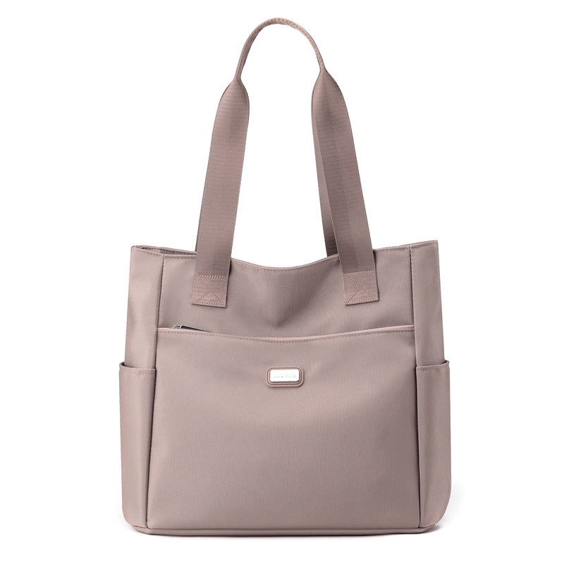 Beige tote bag with multiple pockets on a white background