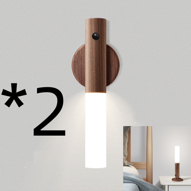 Wooden wall sconce with a white light bulb on a gray wall, with the number 2 displayed.