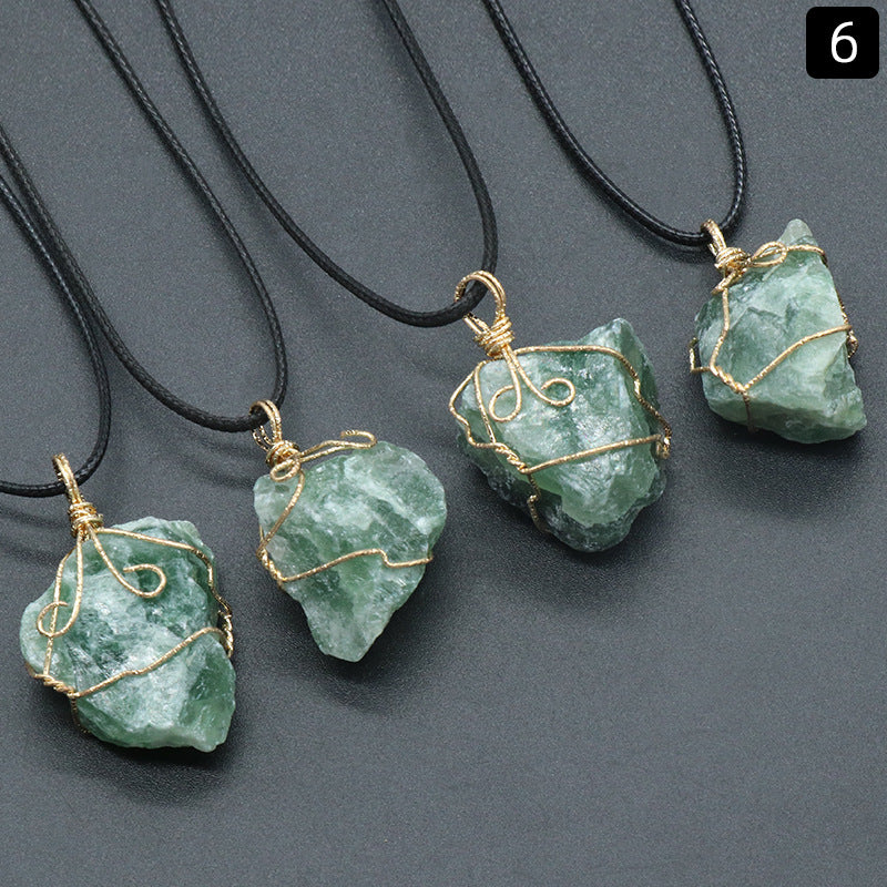 Green stone pendants with gold wire wrapping on black cords against a gray background