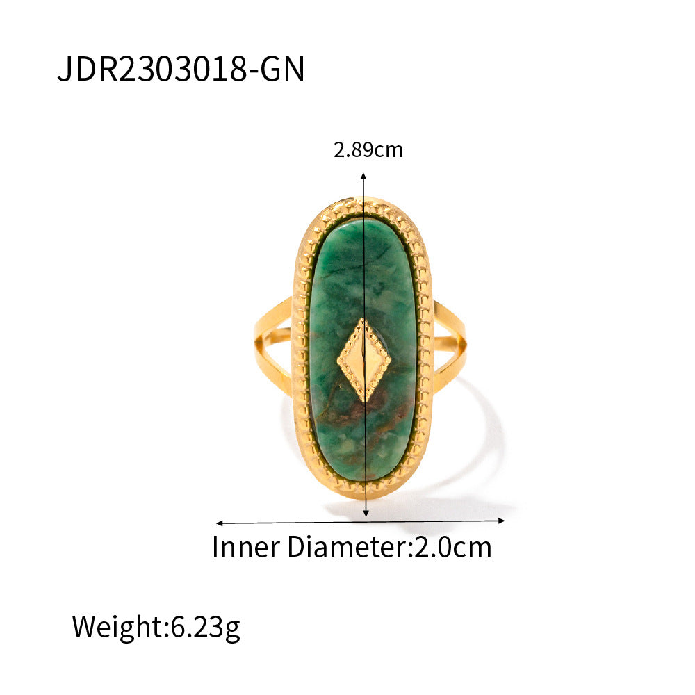 Gold ring with green stone and measurements on a white background