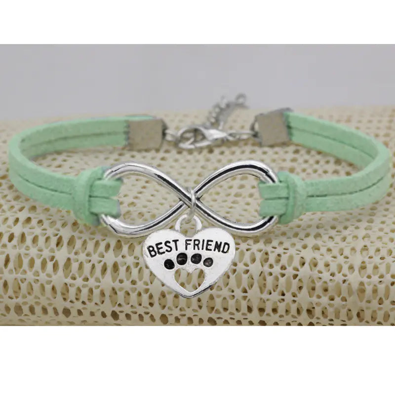 Mint green bracelet with silver infinity symbol and 'Best Friend' heart charm on a textured surface.