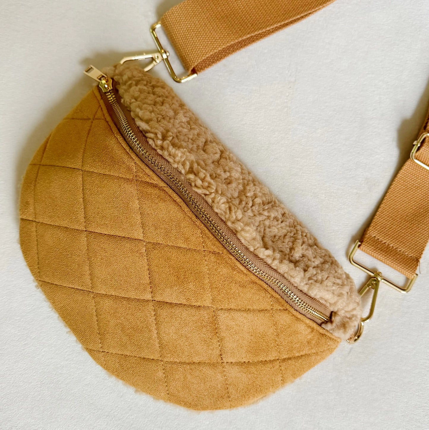 Brown quilted fanny pack with shearling lining on a light background