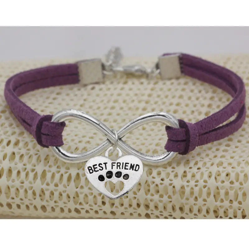 Purple bracelet with silver infinity charm and 'Best Friend' heart tag on a textured surface