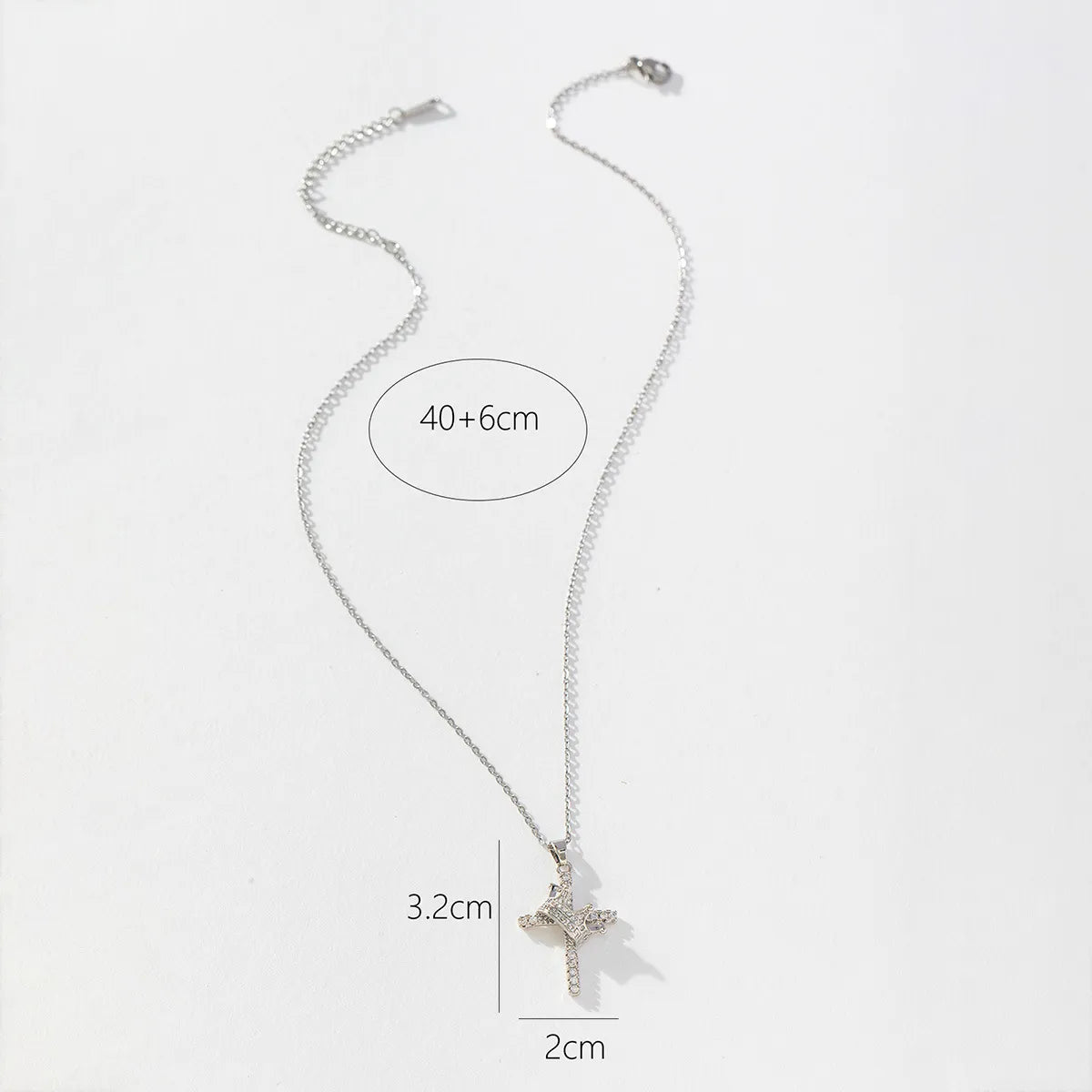 Silver necklace with a cross pendant on a white background