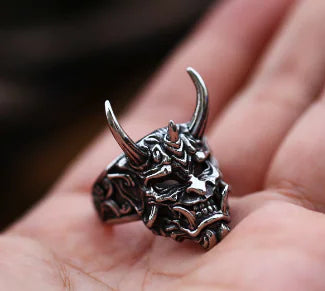 Silver dragon head ring held in a hand