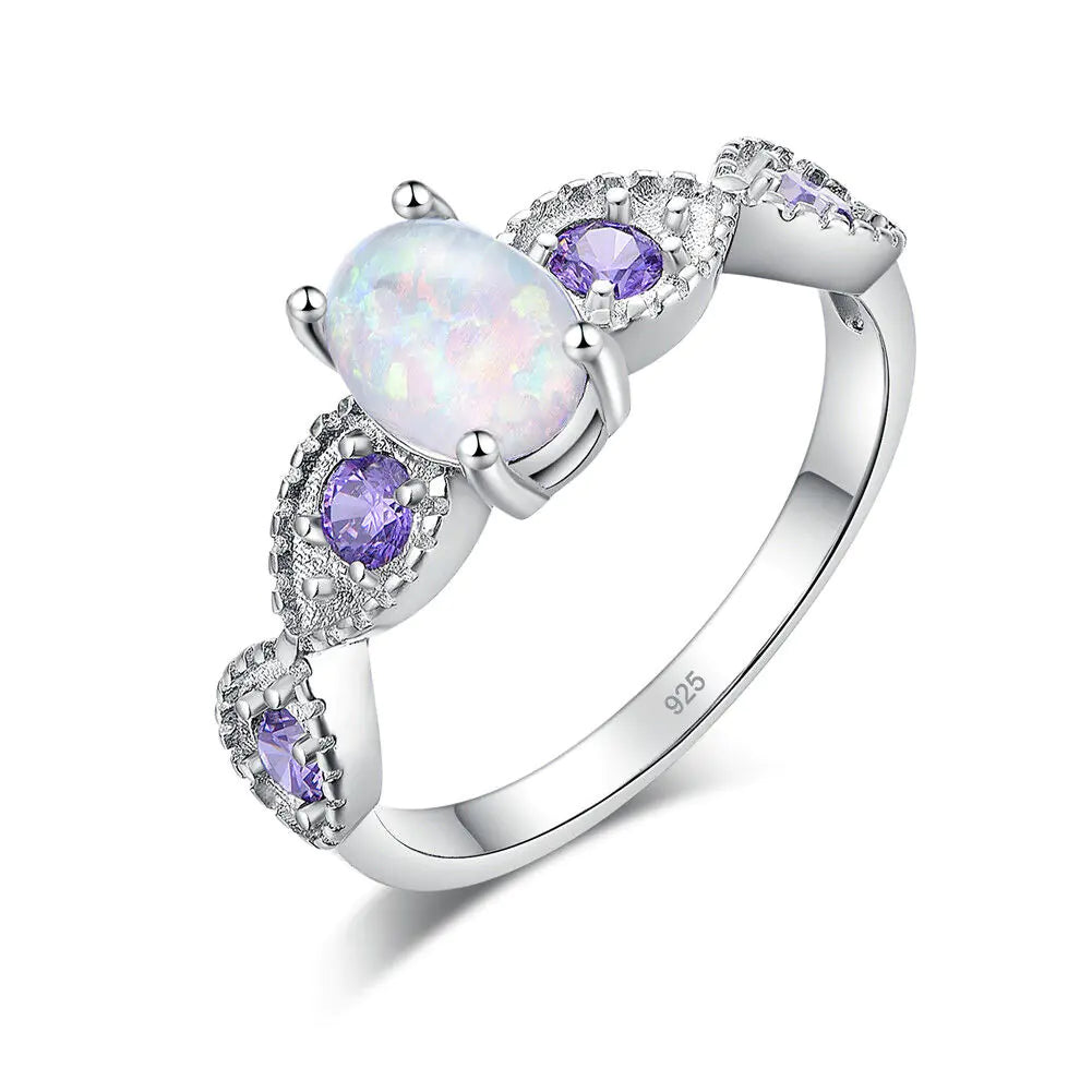 Silver ring with opal and purple gemstones on a white background