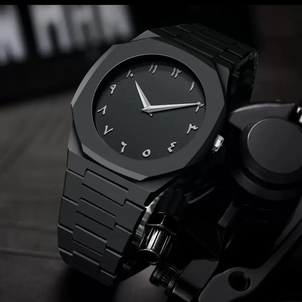 Black wristwatch with a metallic finish on a dark background