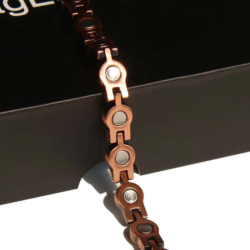 Close-up of a copper chain bracelet on a black background