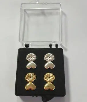 Set of heart-shaped earrings in gold and silver on a display card.