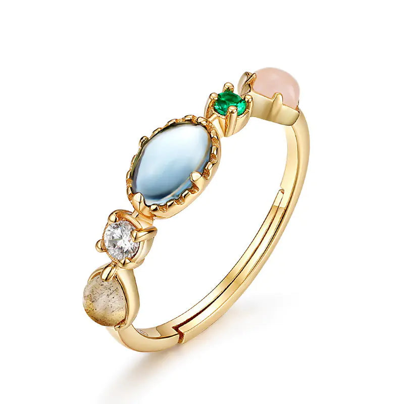 Gold ring with multicolored gemstones on a white background
