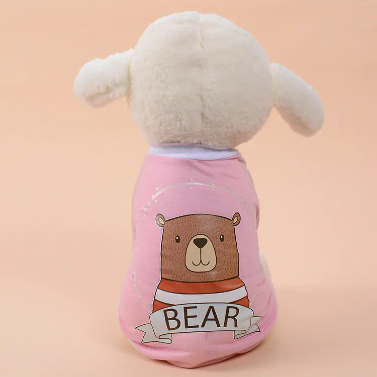 Dog wearing a pink sweater with a bear design on a beige background