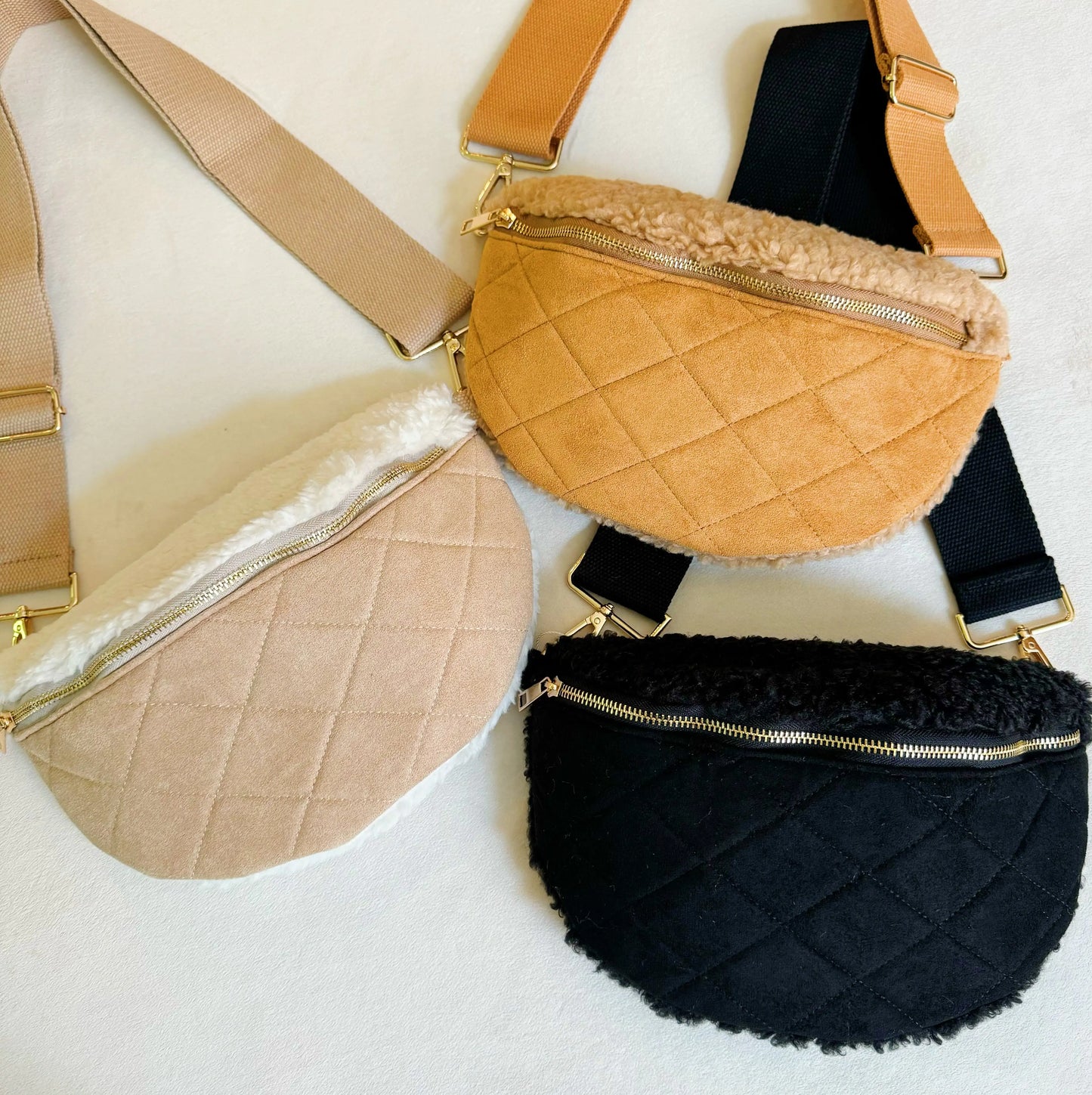 Three quilted fanny packs in beige, black, and brown on a light background