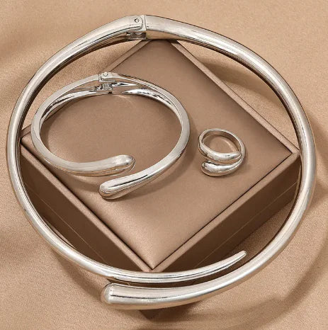 Silver bracelet and ring on a beige background